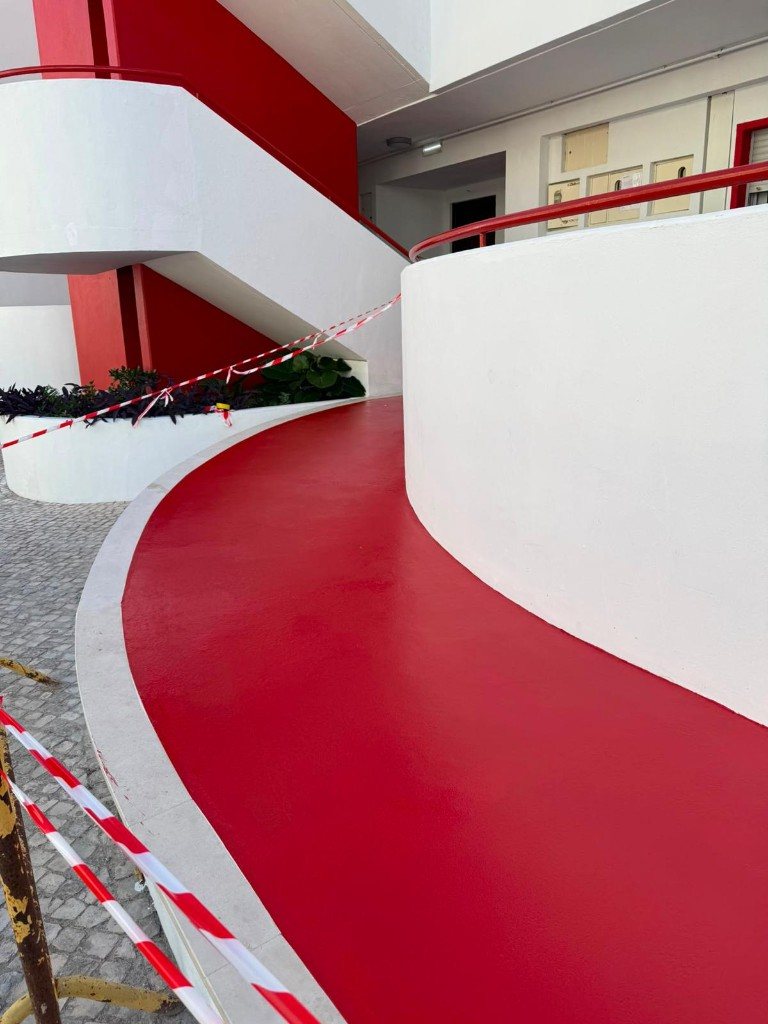 Acesso exterior curvo com pavimento epóxi vermelho